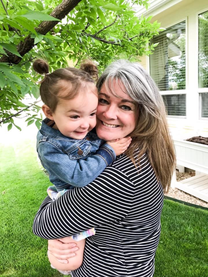 Shana Graver, founder of The Learning Garden, holding a child outdoors