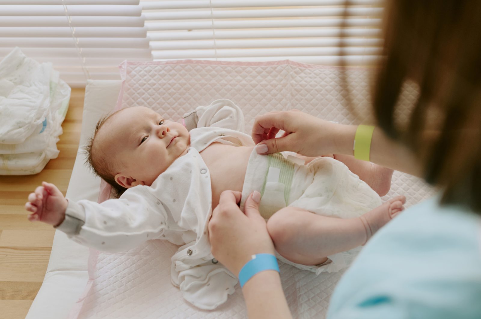 A caregiver gently changing a baby in our infant room
