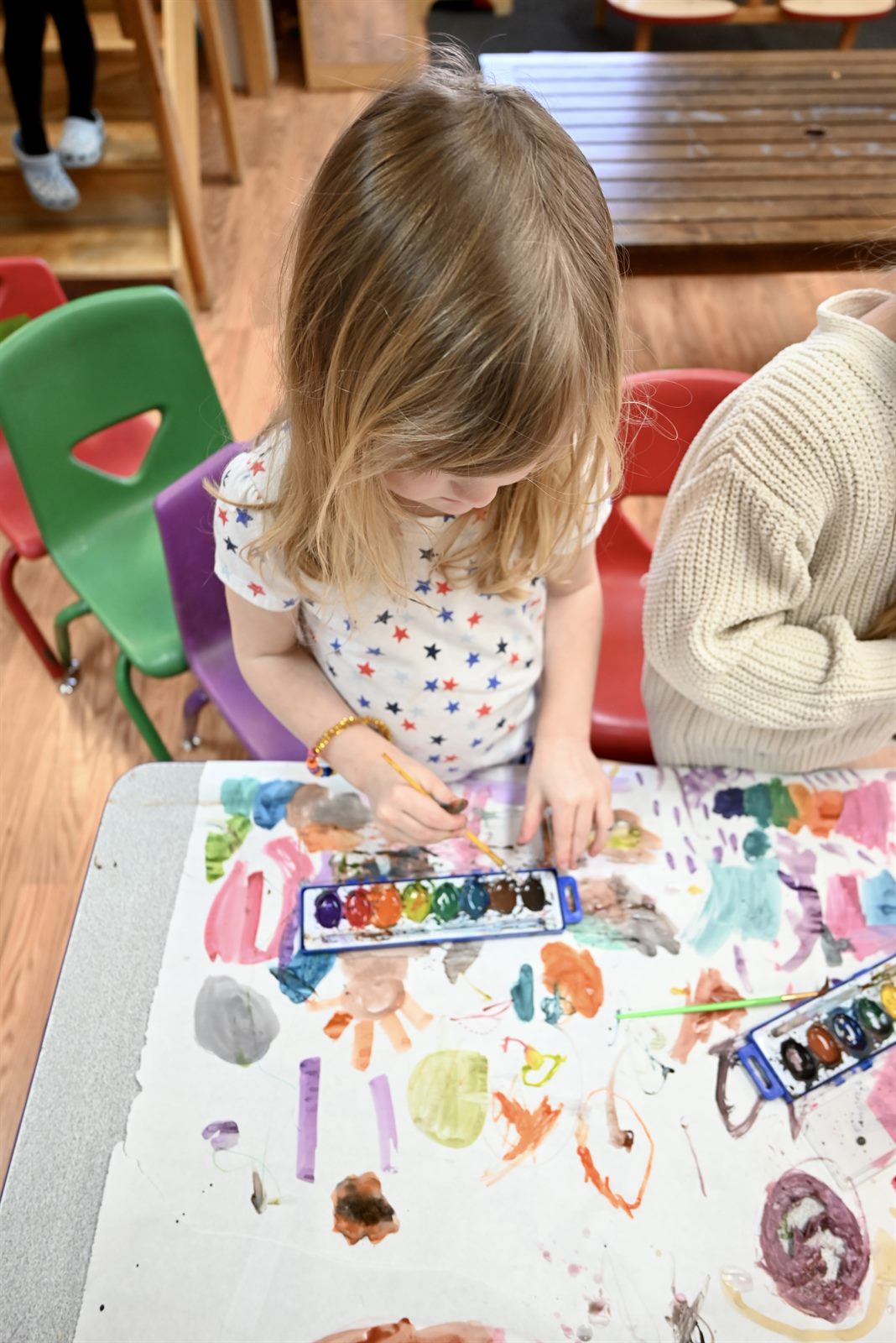 A preschooler painting at the art table