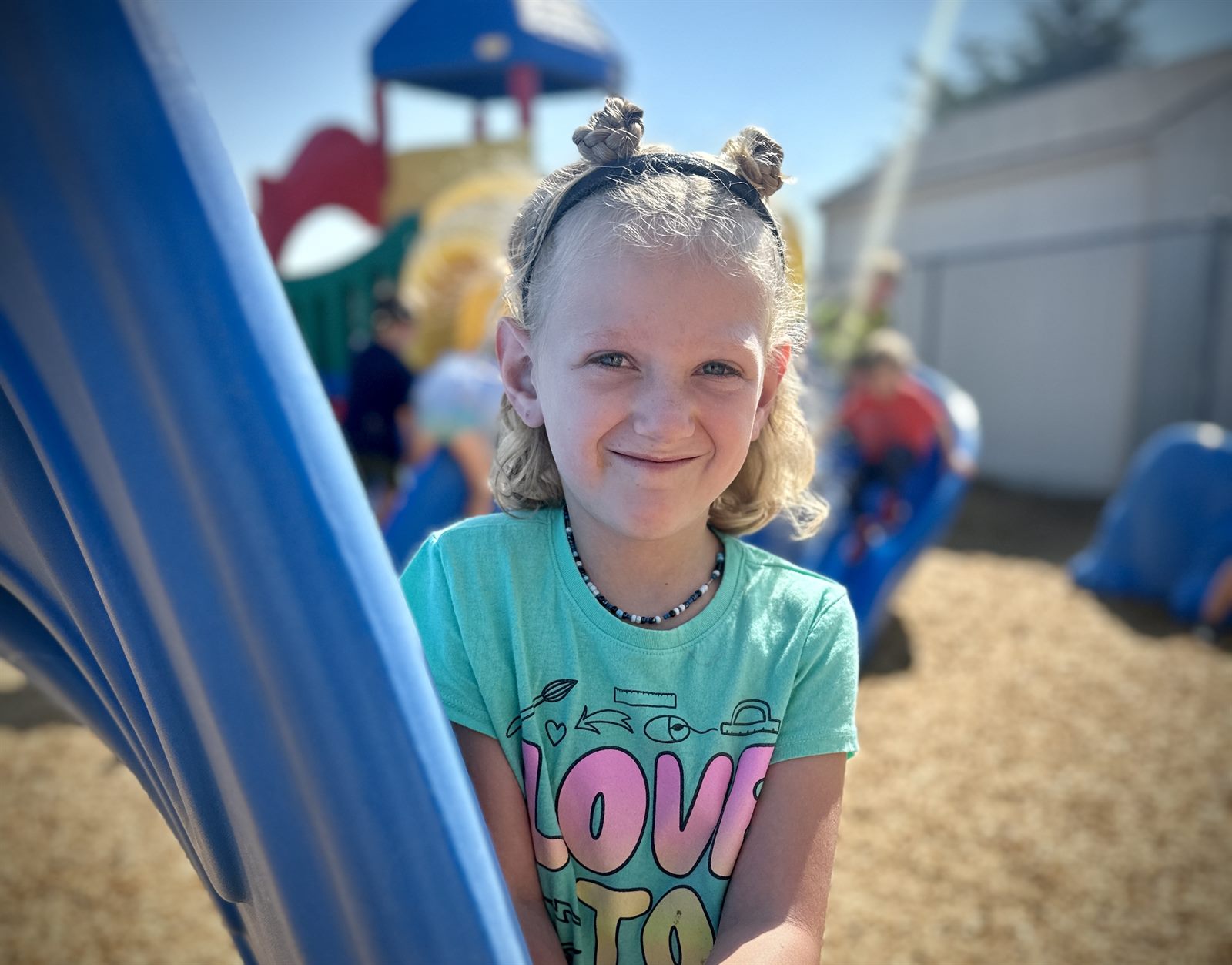 A school-age child smiling outdoors