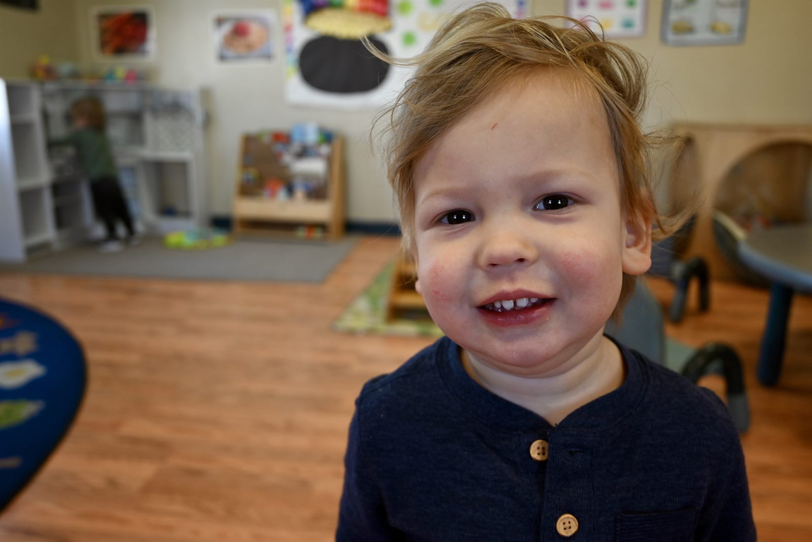A happy toddler smiling in our classroom