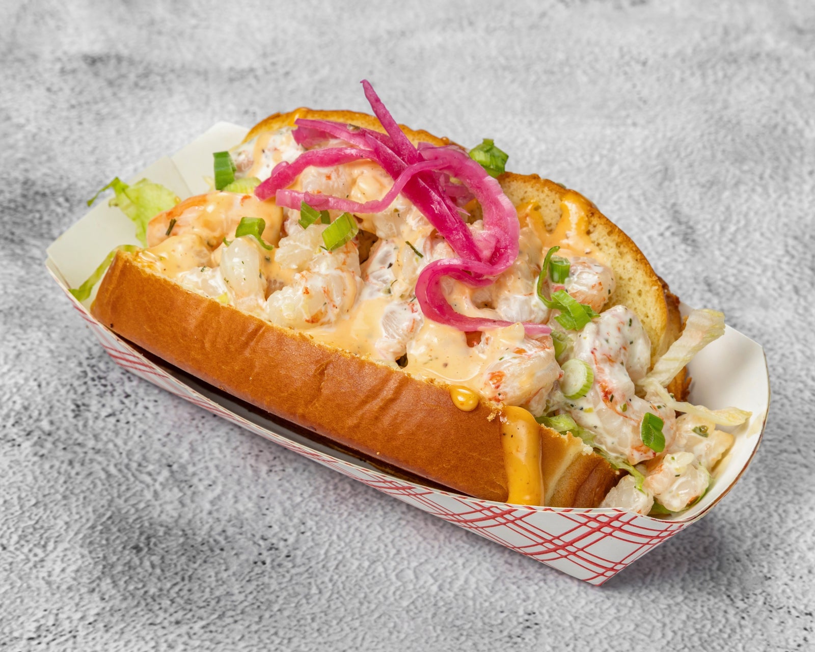 Seafood roll on a toasted bun with slaw and crispy fries