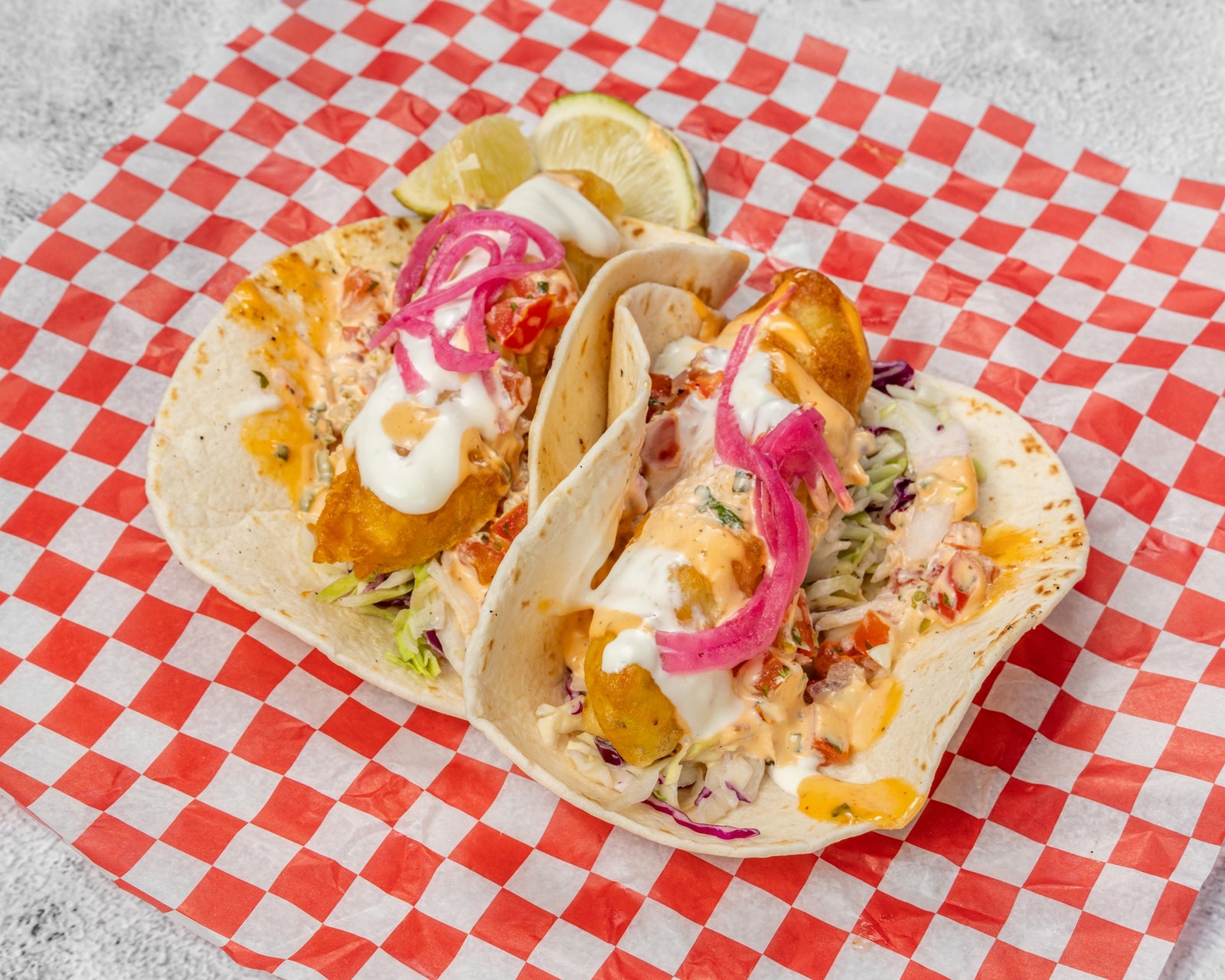 Fish tacos with pineapple salsa on a wooden surface