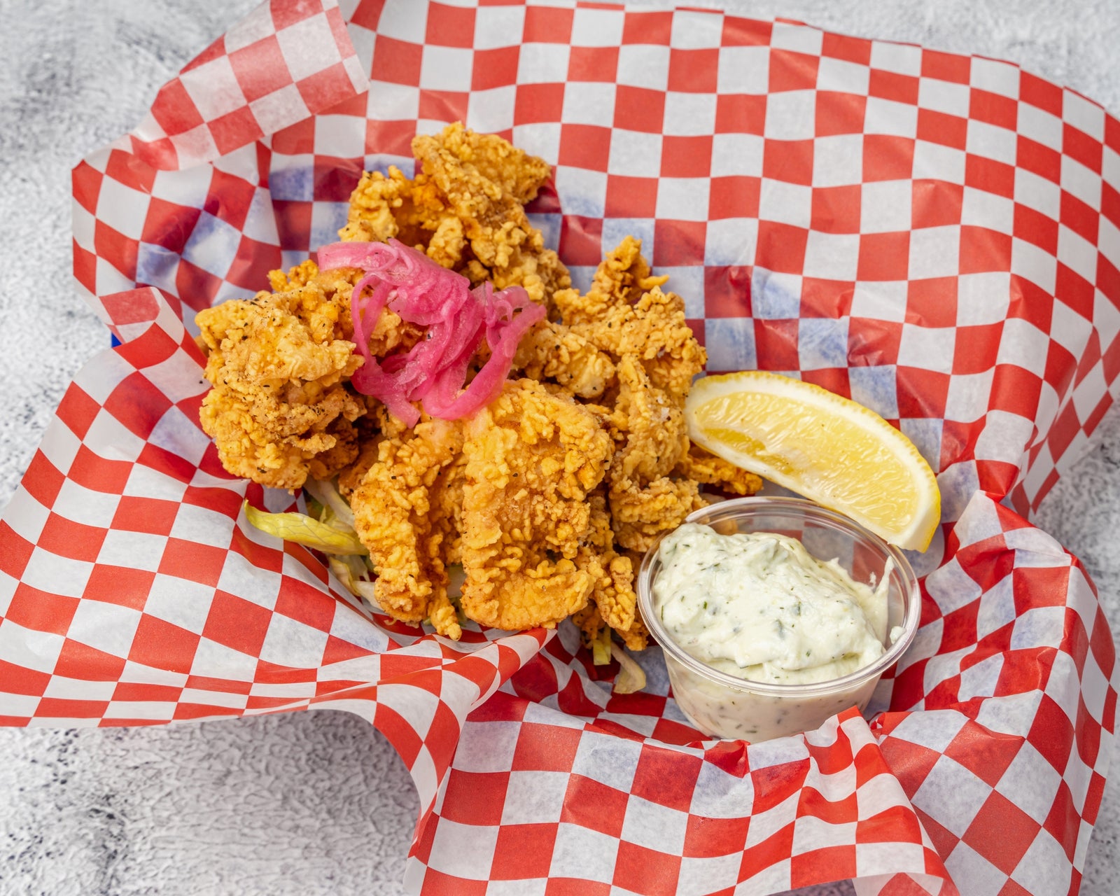 Crispy fried calamari rings with tartar sauce, pickled peppers, and lemon