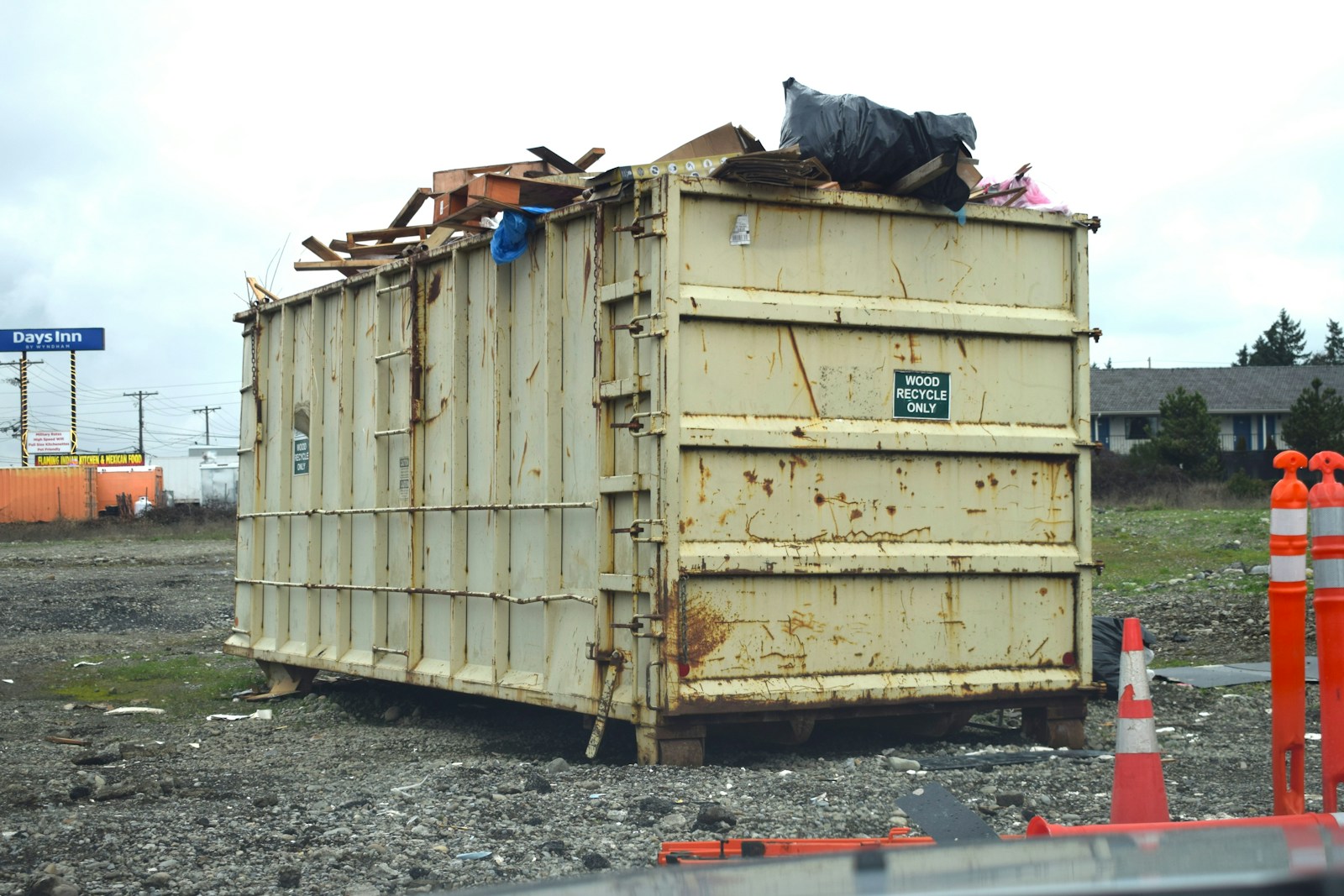 Large roll-off dumpster on a job site next to safety cones