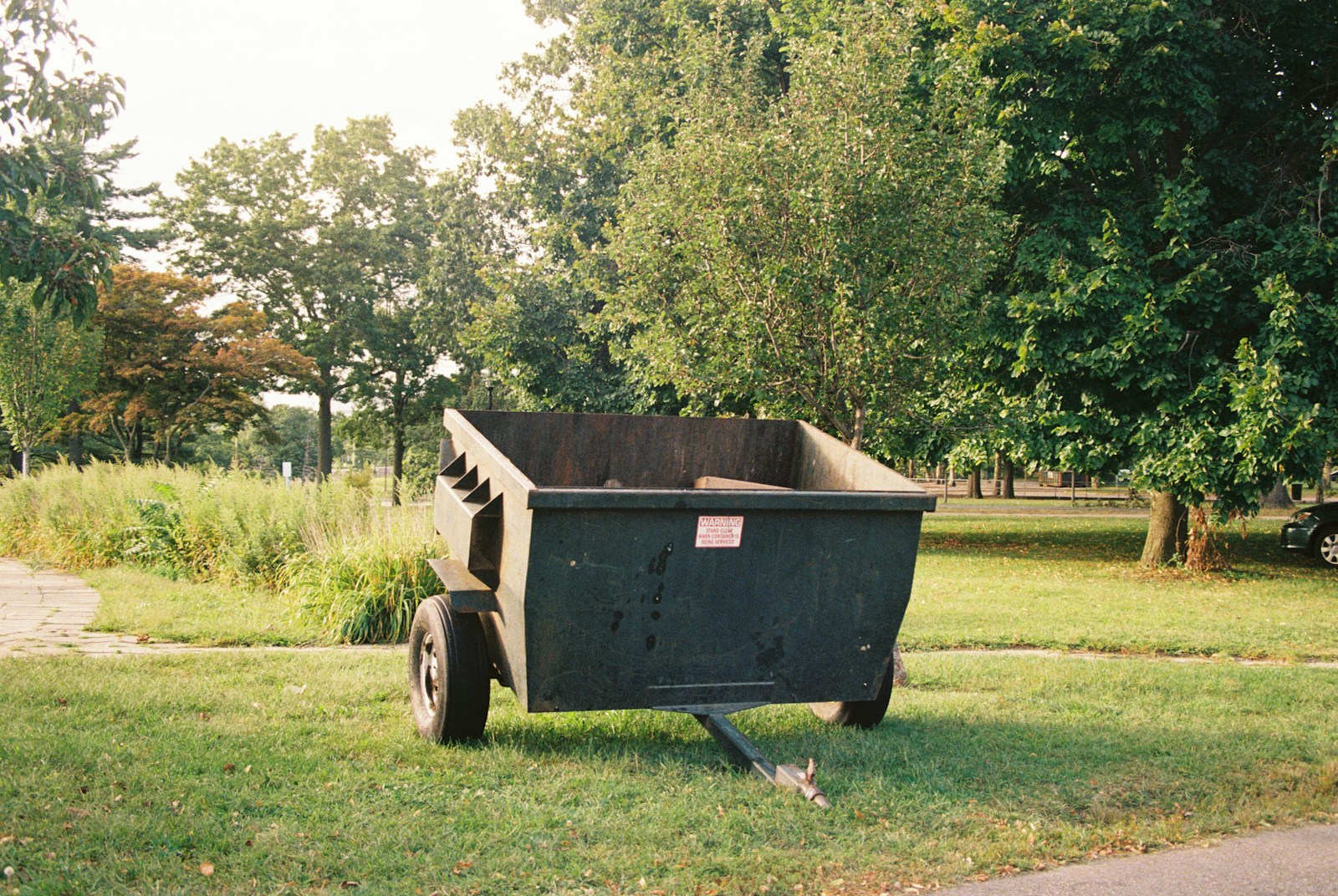 Small open-top dumpster on a grassy lot