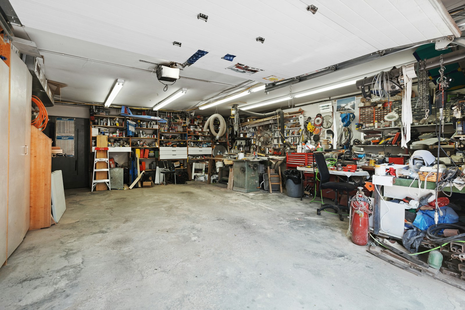Cluttered two-car garage full of tools and stored items before a cleanout