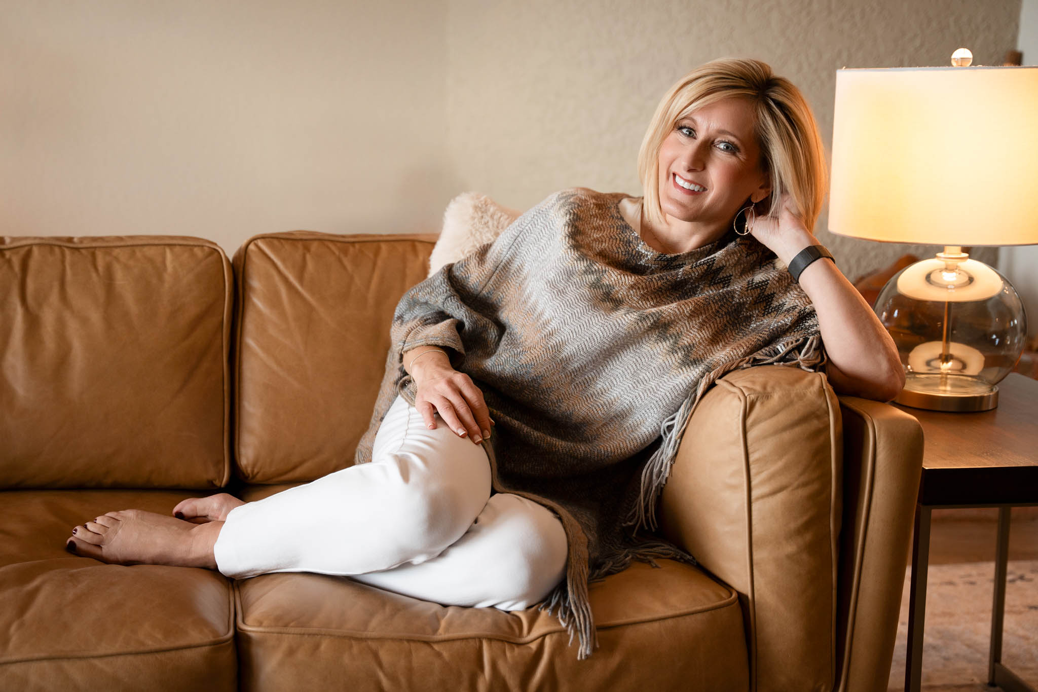 Lifestyle branding photo of female entrepreneur relaxing on leather couch in warm neutral tones | Jessica Korff Studios Tucson, AZ