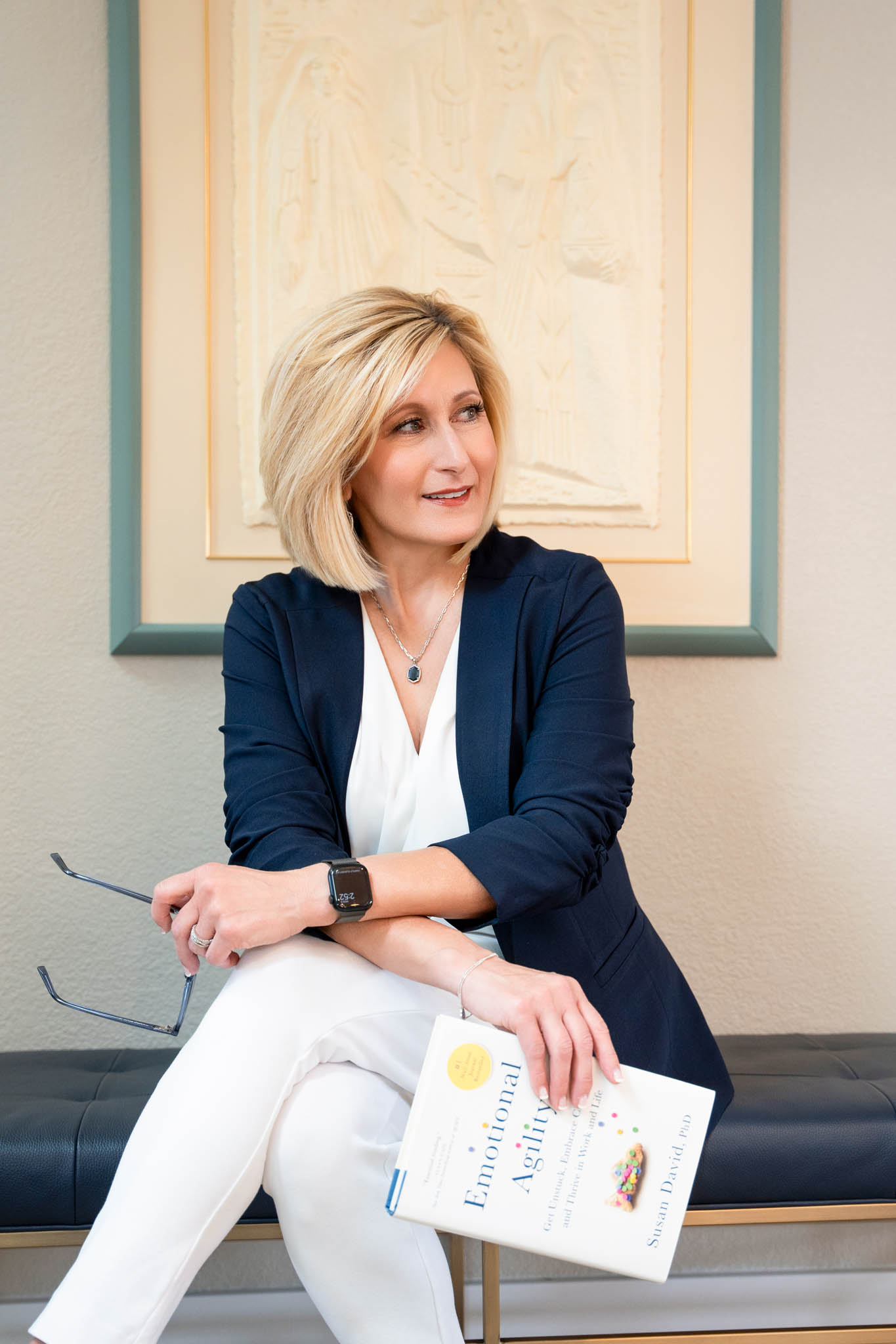 Professional woman holding book and glasses, polished and elevated branding portrait | Jessica Korff Studios Tucson, AZ