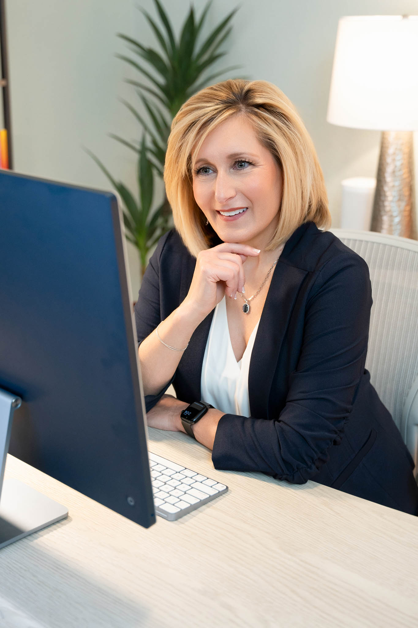 Professional woman working at desktop computer in modern office branding session | Jessica Korff Studios Tucson, AZ