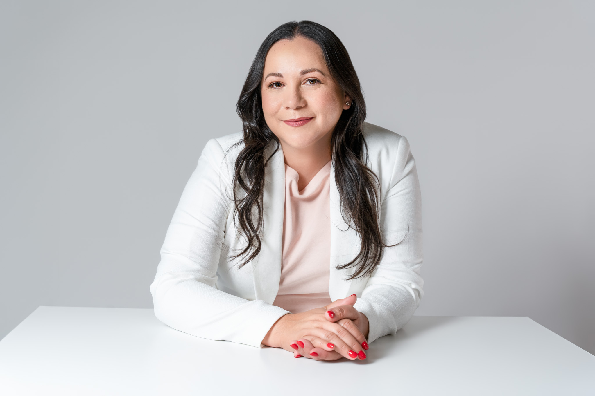 Female entrepreneur sitting at a table with hands clasped during a modern branding session | Jessica Korff Studios Tucson, AZ