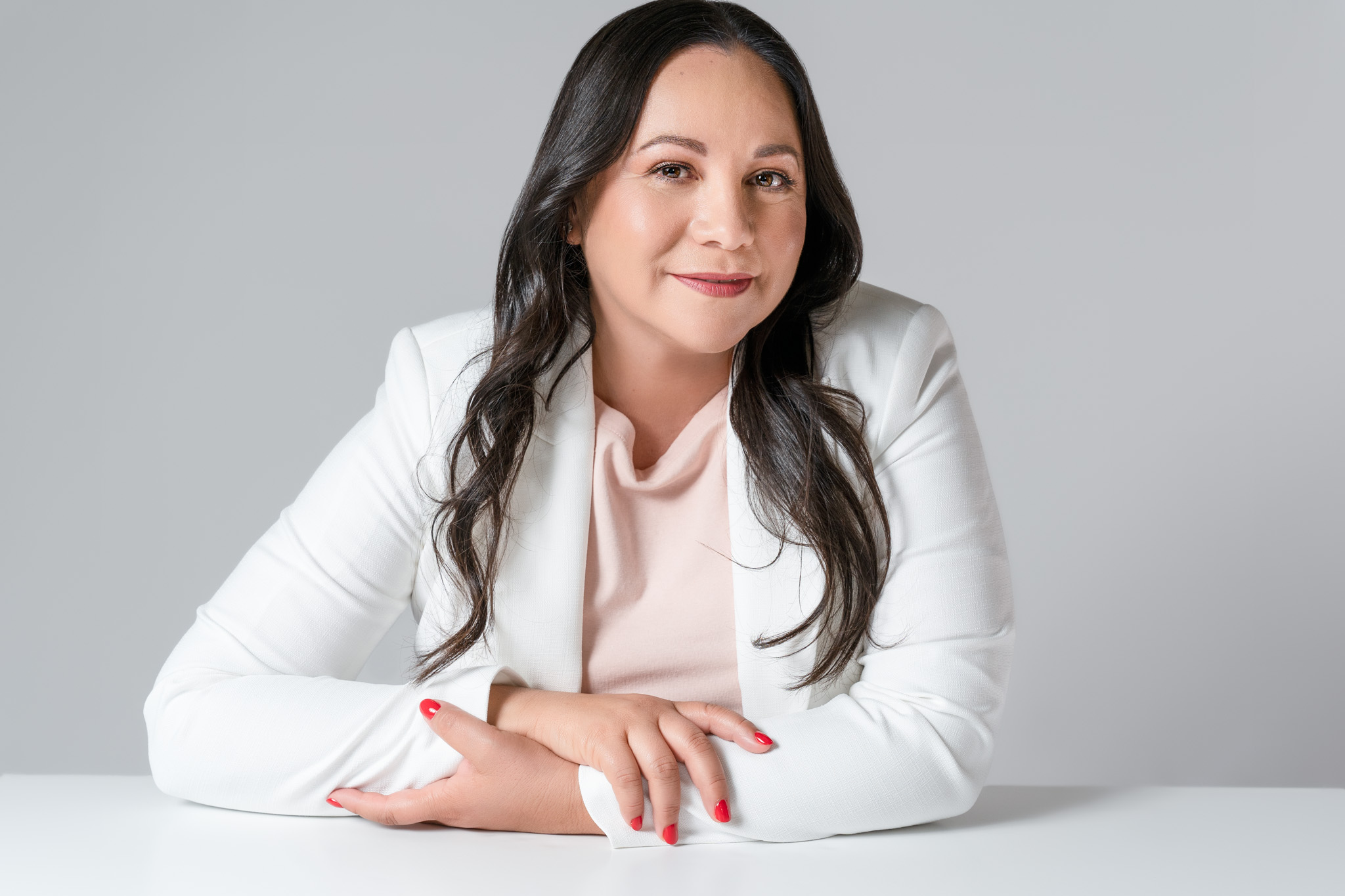 Female entrepreneur sitting at a table with hands clasped during a modern branding session | Jessica Korff Studios Tucson, AZ