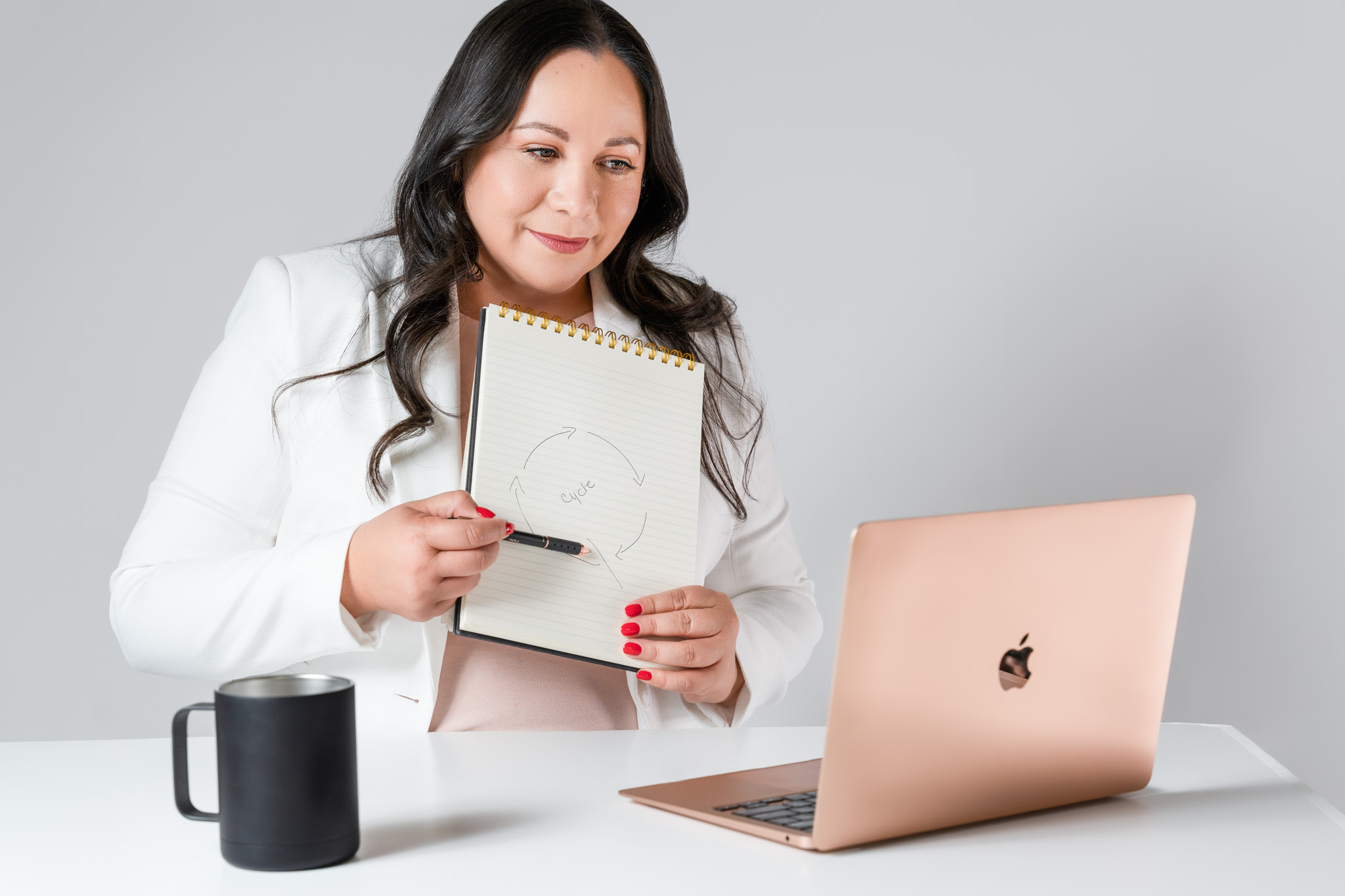 Indoor lifestyle branding image of confident woman holding a notebook looking at a computer | Jessica Korff Studios Tucson, AZ