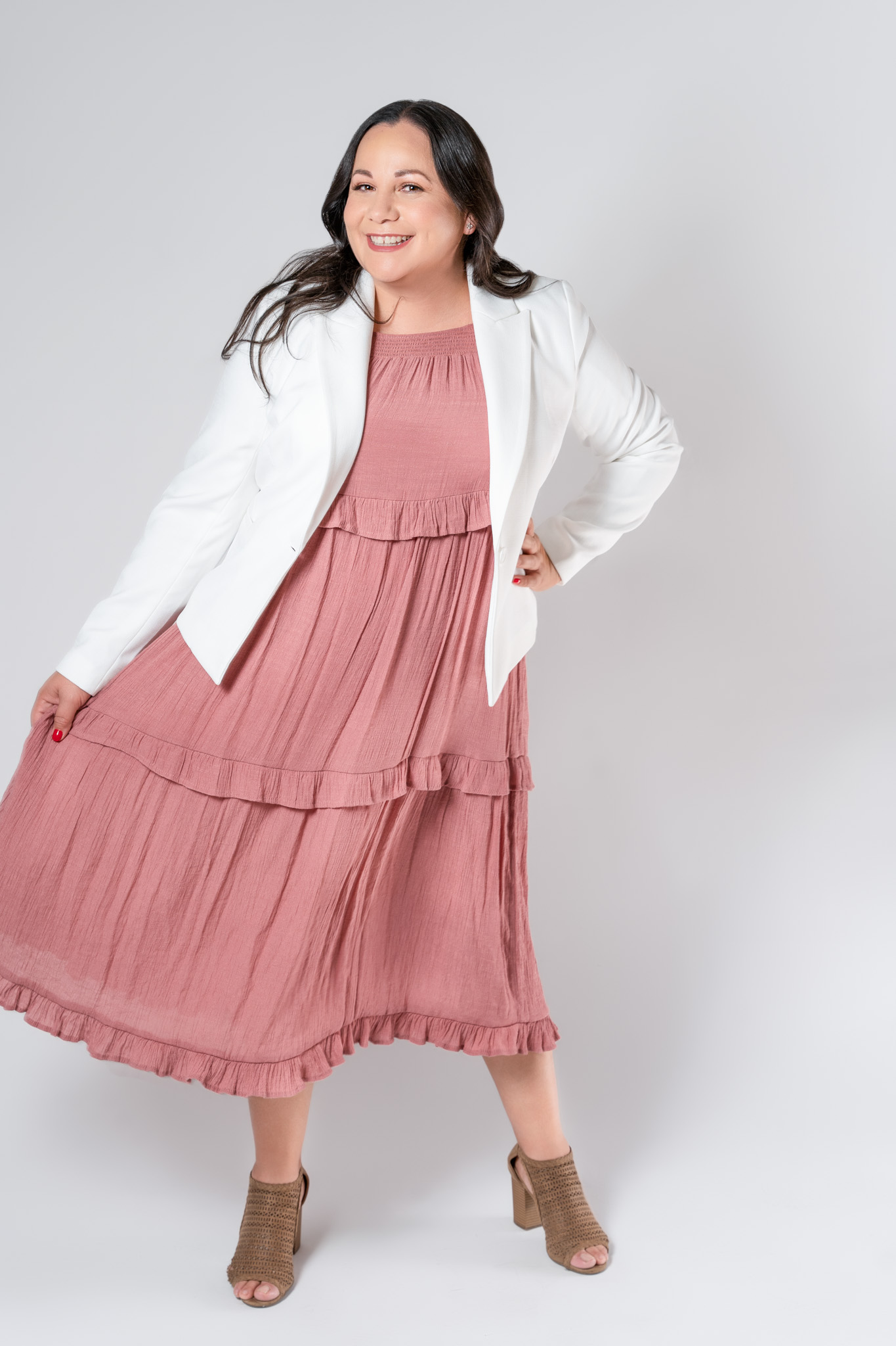 Woman holding pink dress with hand on hip, approachable and confident lifestyle branding image | Jessica Korff Studios Tucson, AZ