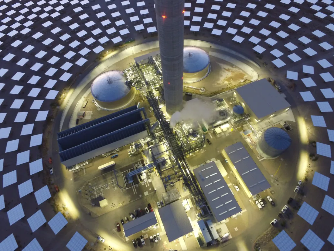 Looking down on the center of the plant: the base of the tower, the molten salt tanks and the power block, ringed by heliostats.