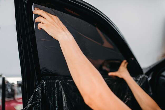 Specialist installing ceramic window tint film on a vehicle in Arizona