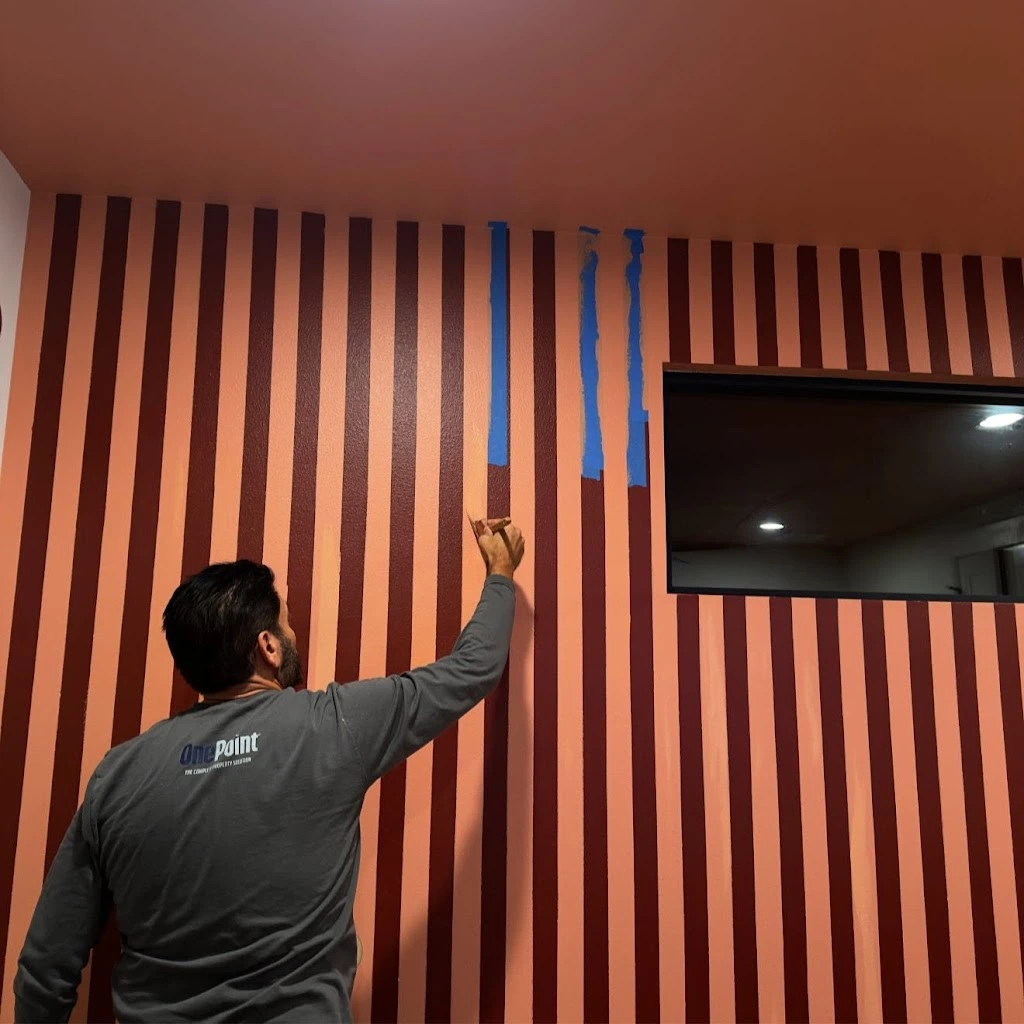 OnePoint painter masking a striped feature wall on site