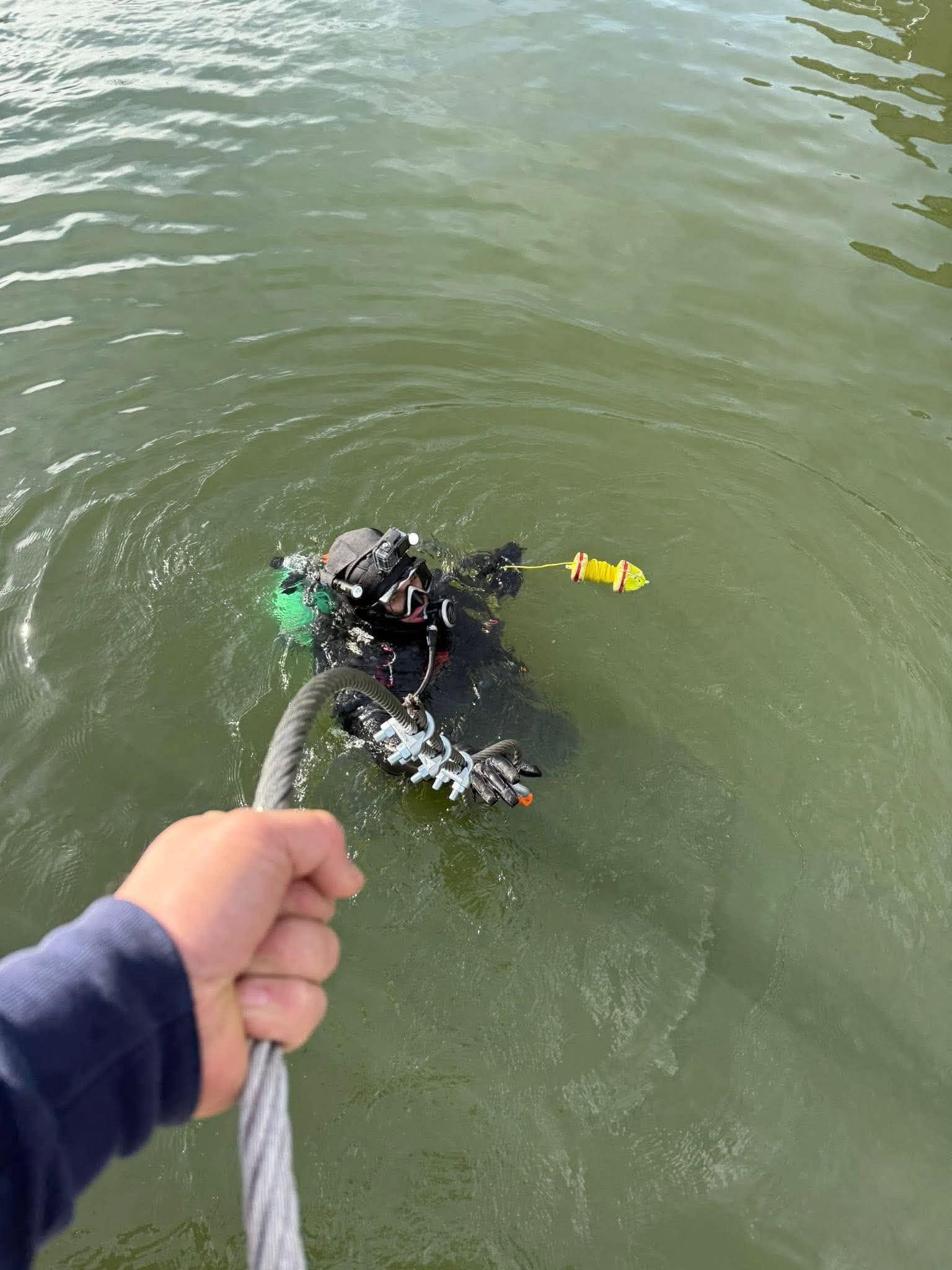LOZ Dive commercial diver inspecting a dock cable underwater