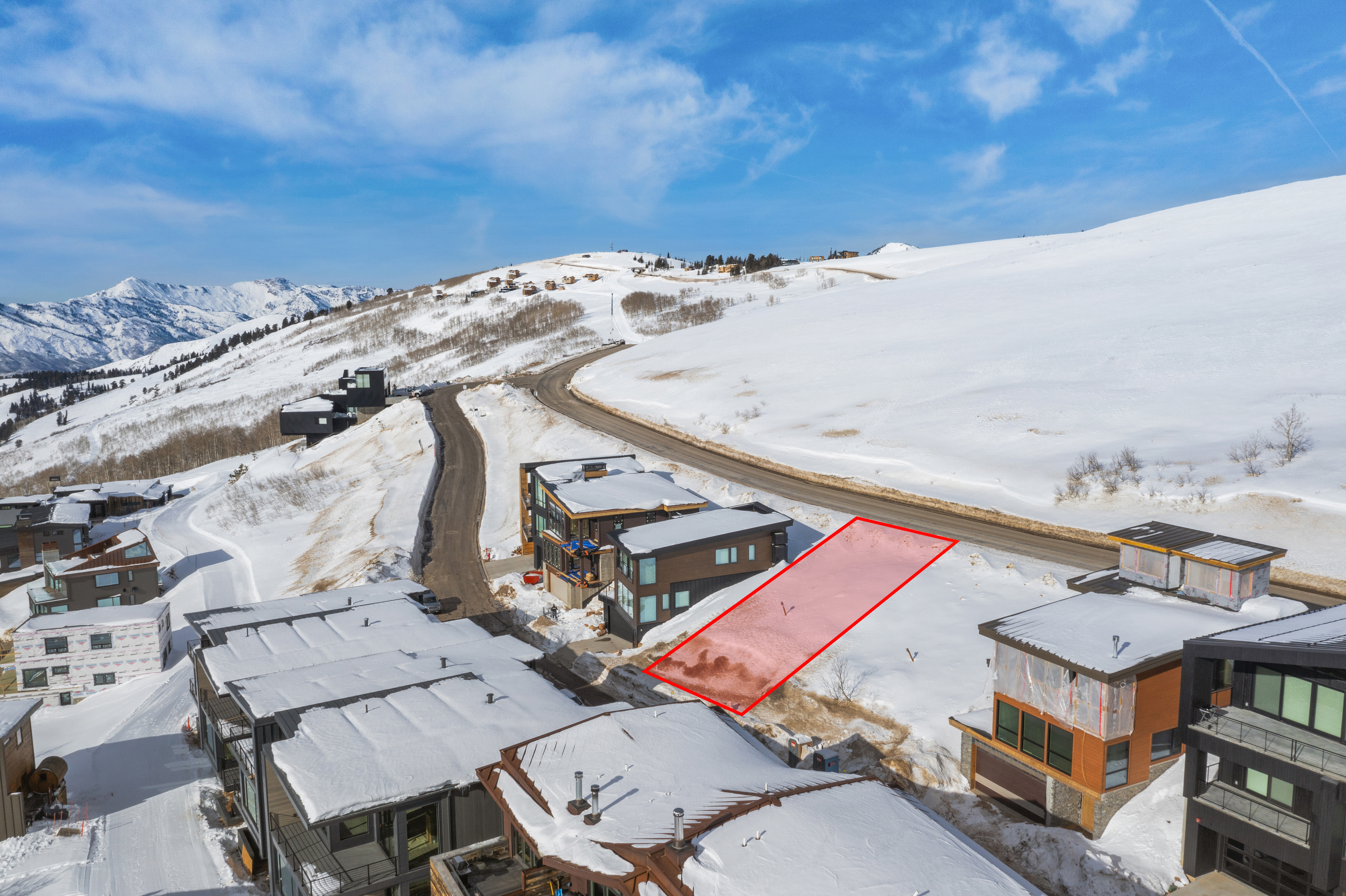 Aerial view of a snow-covered home site marked with a boundary overlay