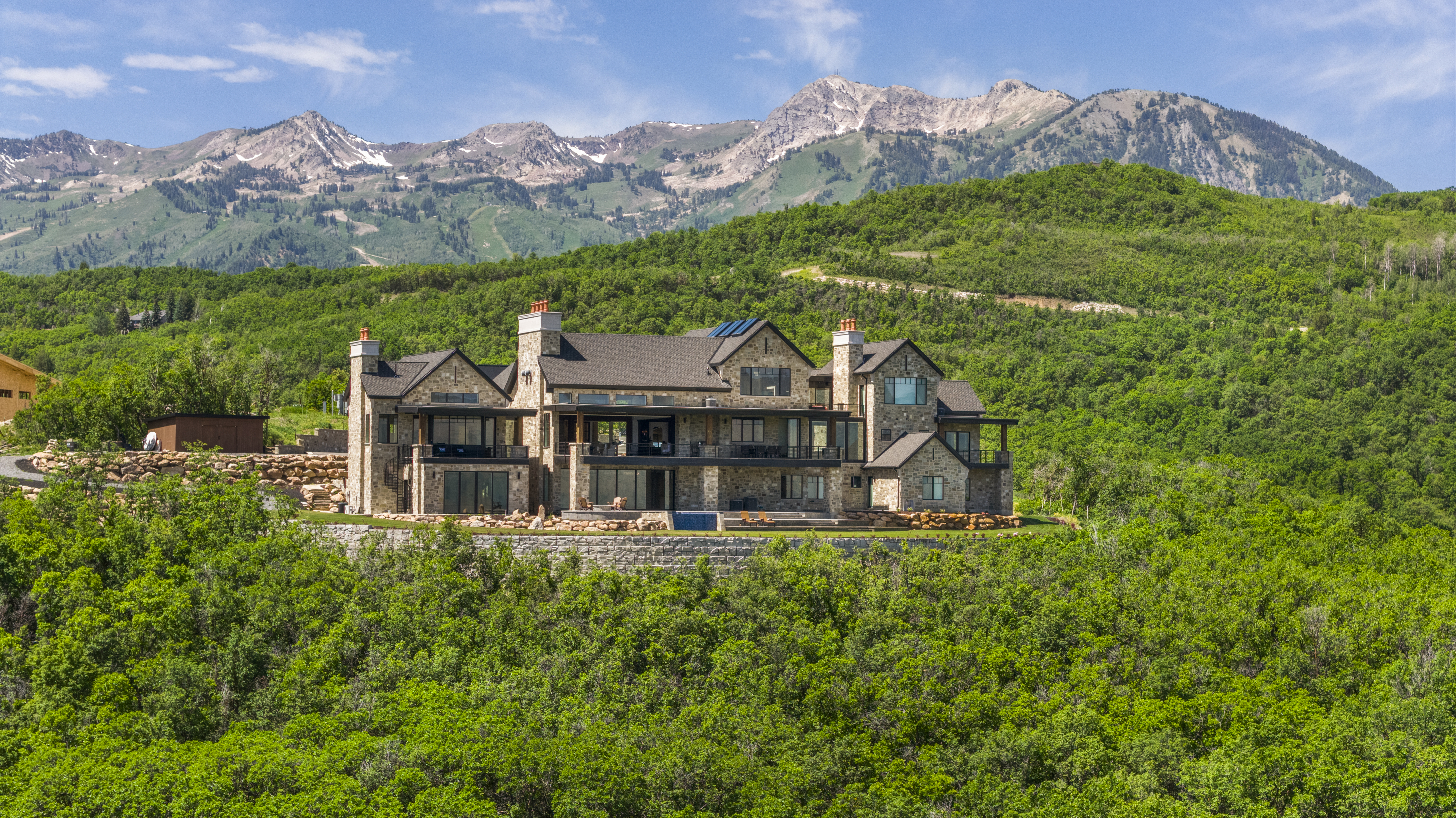 Daytime aerial view of a Northern Utah home surrounded by mountains
