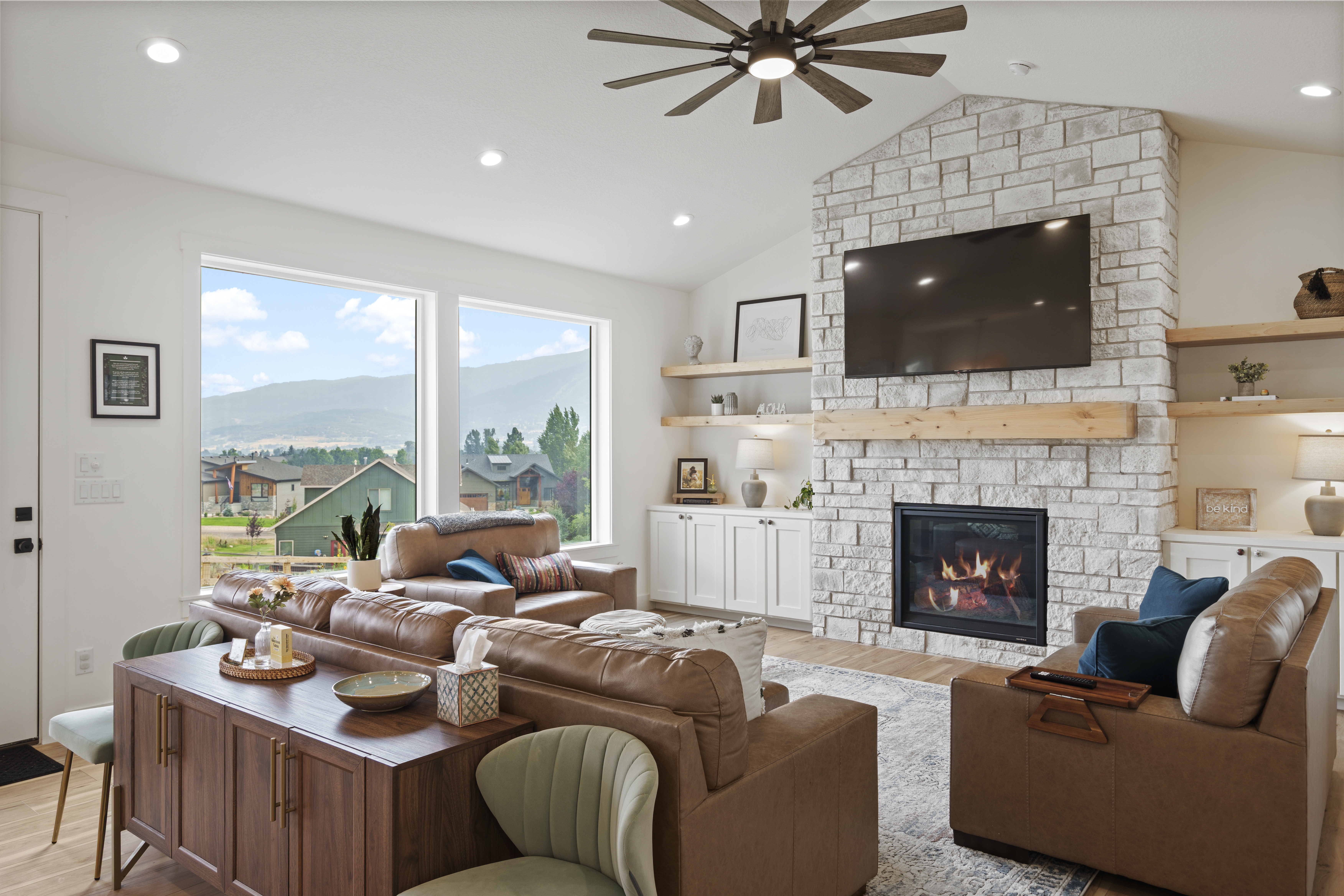 Living room with stone fireplace and mounted television