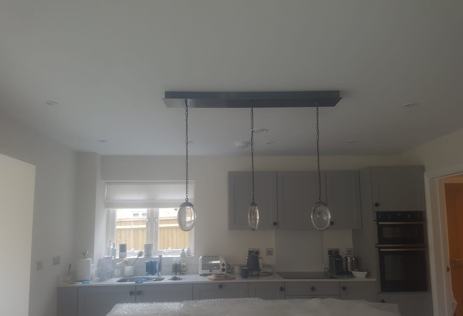 Linear pendant light fitted above a kitchen island