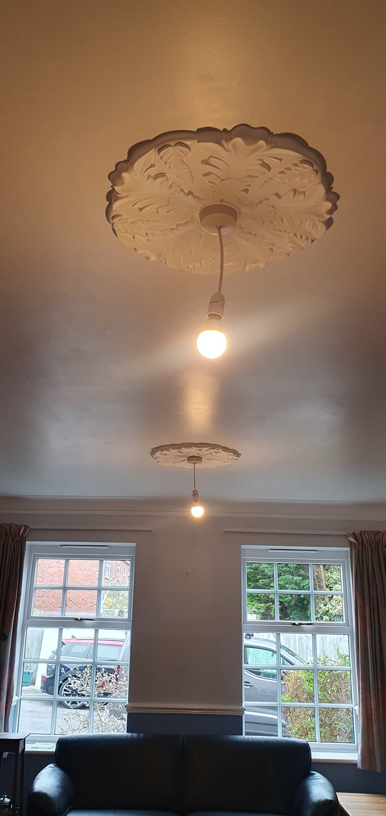 Ornate ceiling rose with pendant lighting in a period room