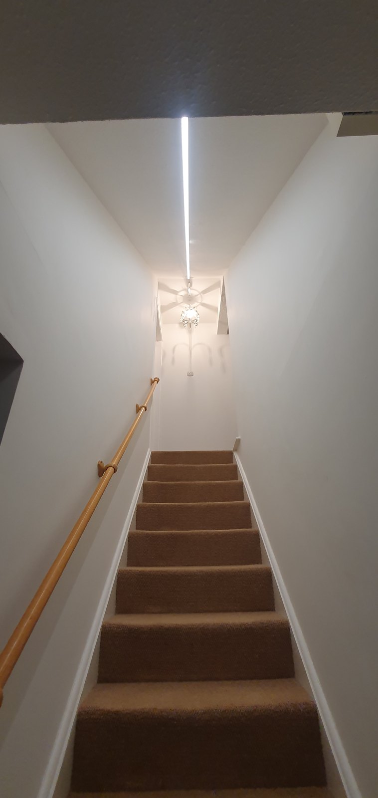 LED strip lighting and a pendant light over a stairwell