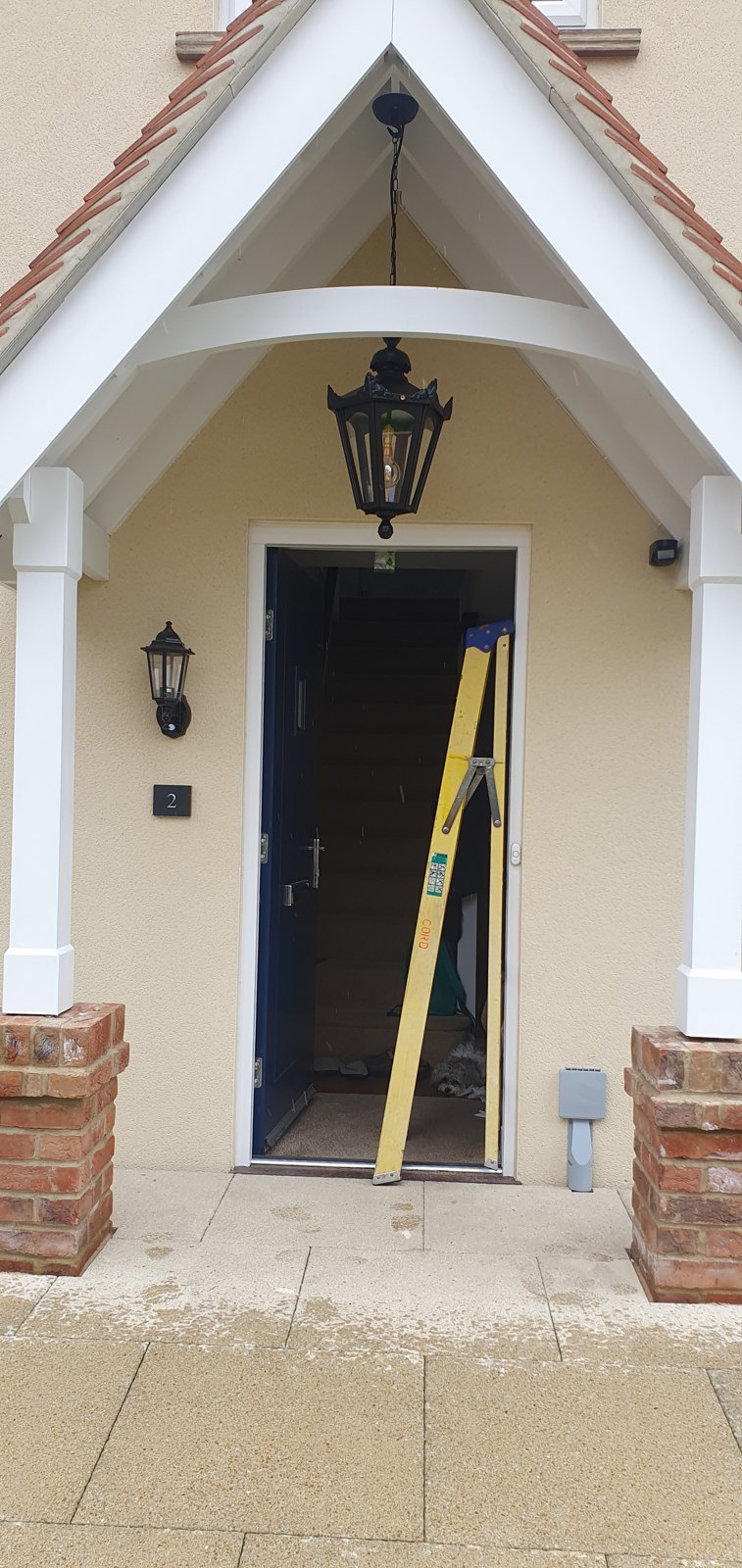 Two carriage lanterns fitted in a porch of a new build home