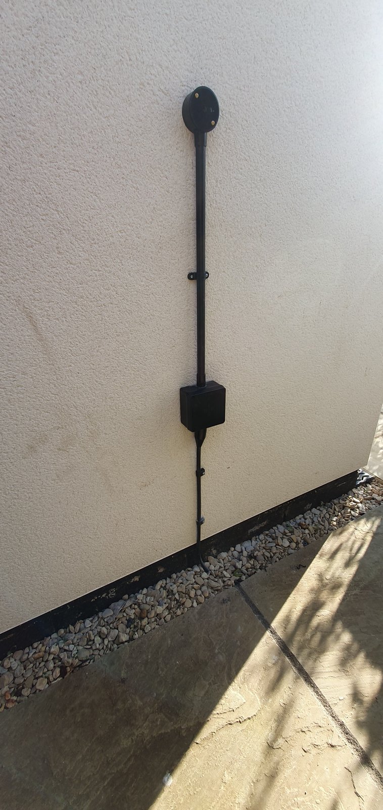 External cable clipped down a rendered wall