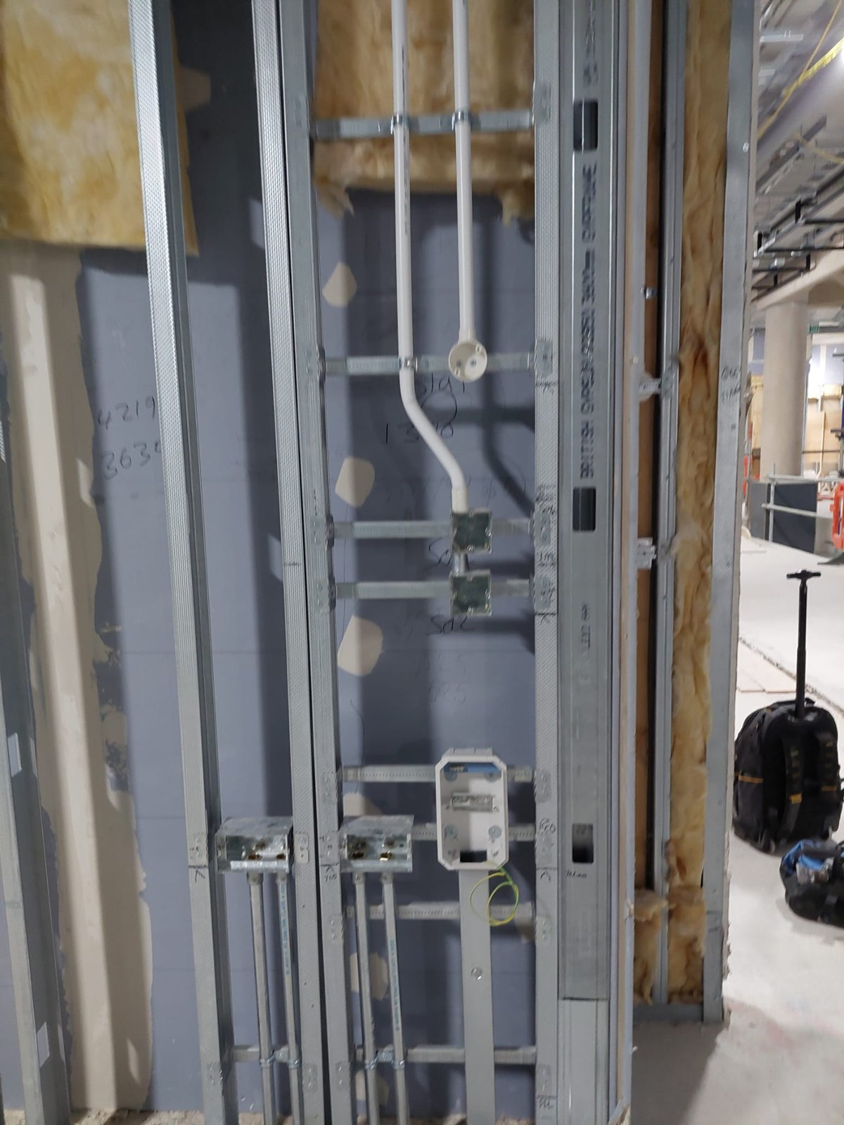 Conduit and cabling run through a metal stud riser