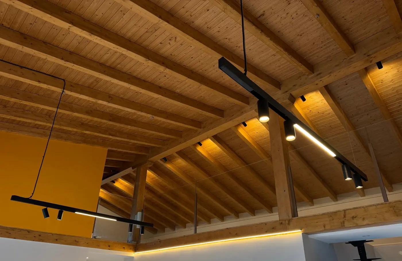 Luz lineal integrada en un techo de vigas de madera