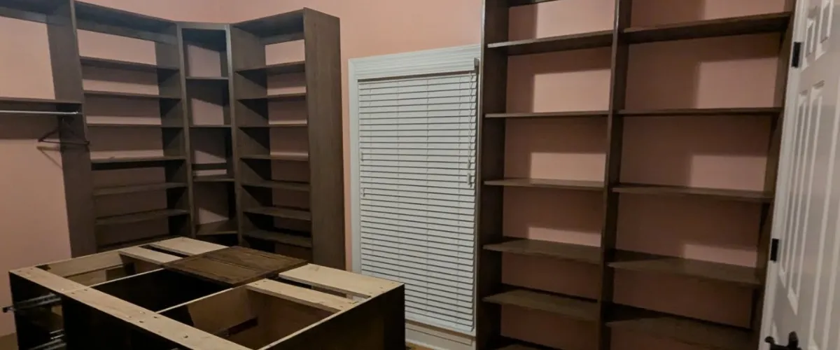A walk-in closet with custom shelves and an open layout for organization and storage solutions.