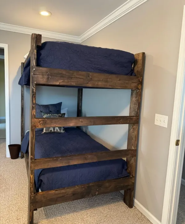  A rustic wooden bunk bed design with a cozy and classic look, ideal for a child's room or guest space.