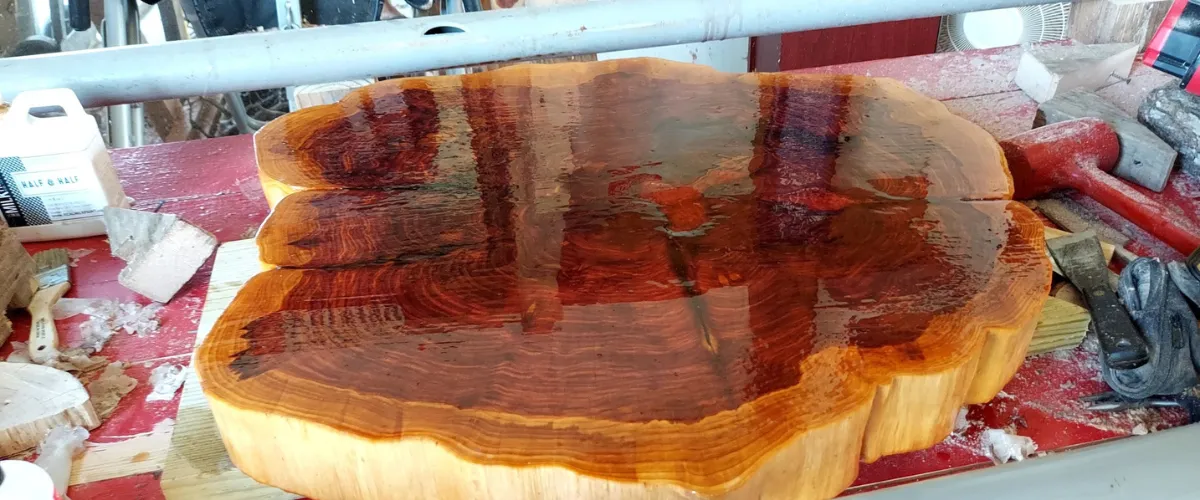 Glossy finished live edge wood slab on a workbench, ready for furniture crafting