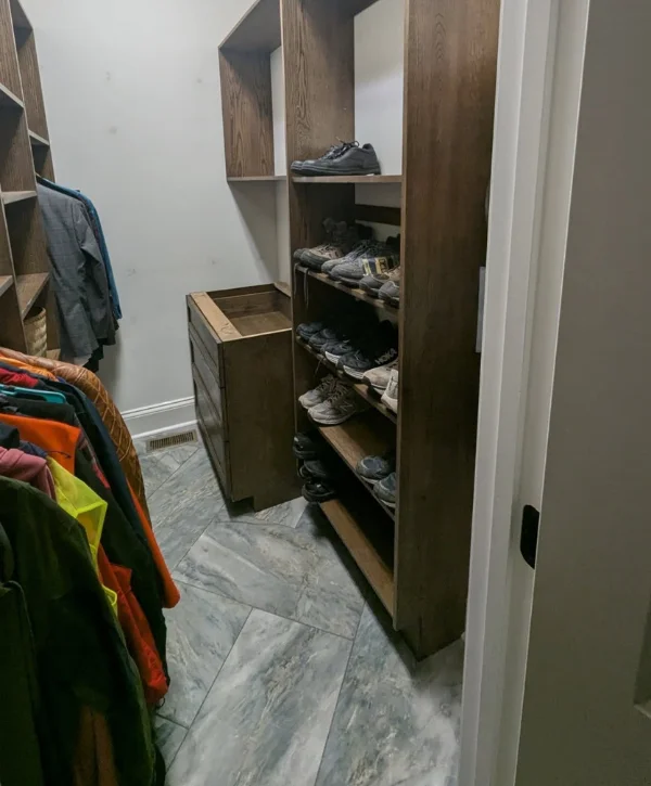 Modern organized closet with shoe racks, hanging clothes, and built-in drawers for optimized storage