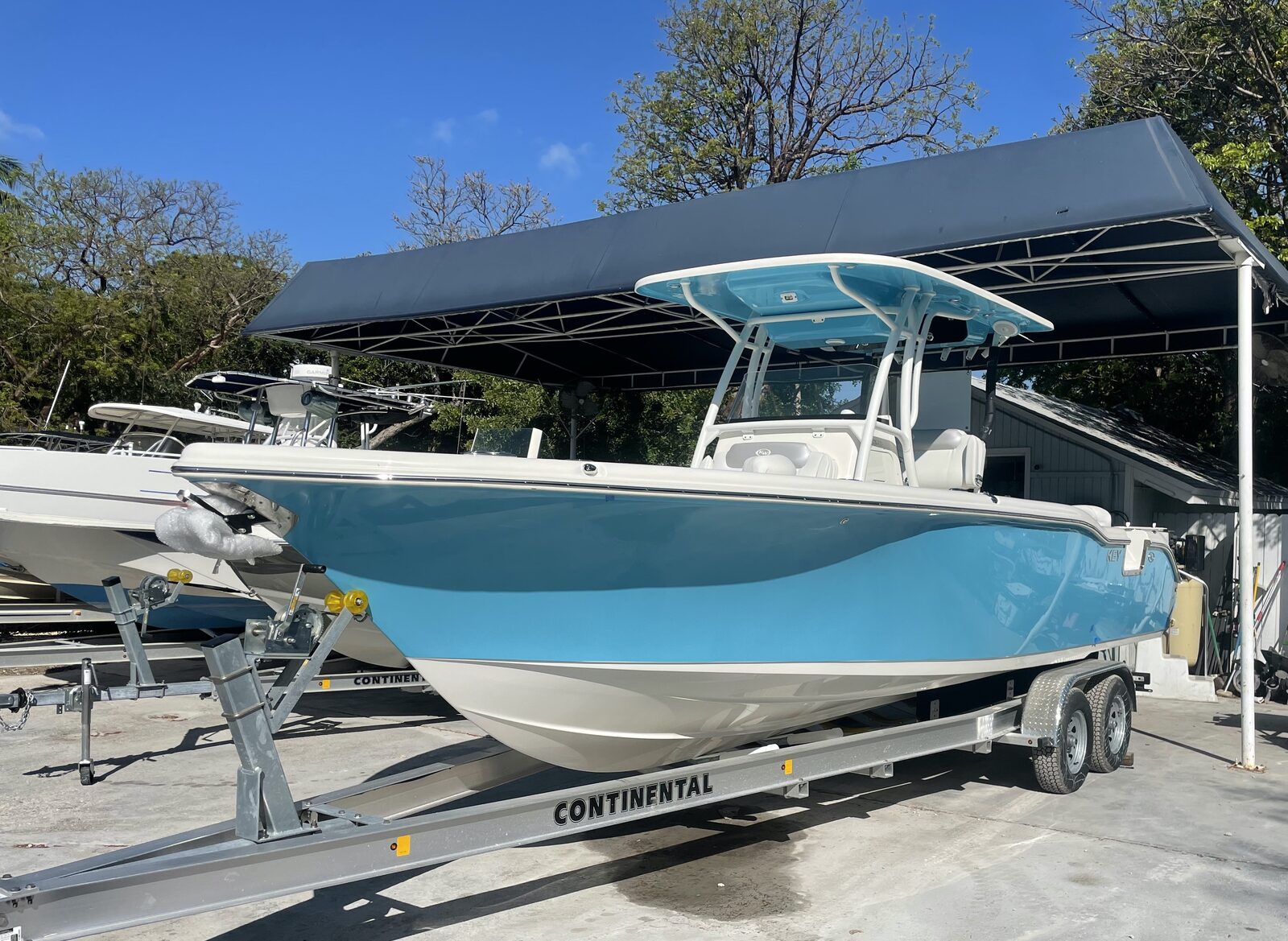 Teal center console boat detailed under dry storage canopy in the Florida Keys