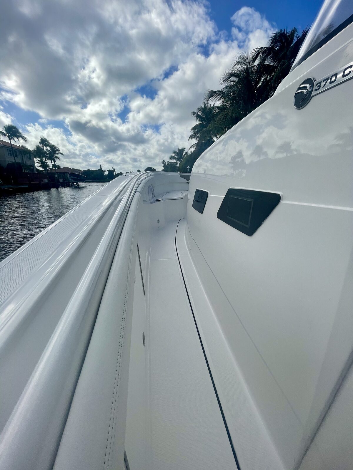 Ceramic coated white boat hull reflecting palm trees in the Florida Keys