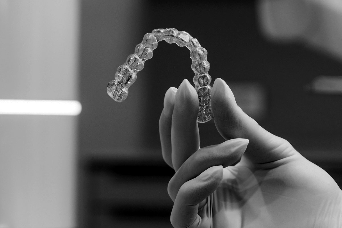 Prozirni Invisalign aligner u ruci stomatologa