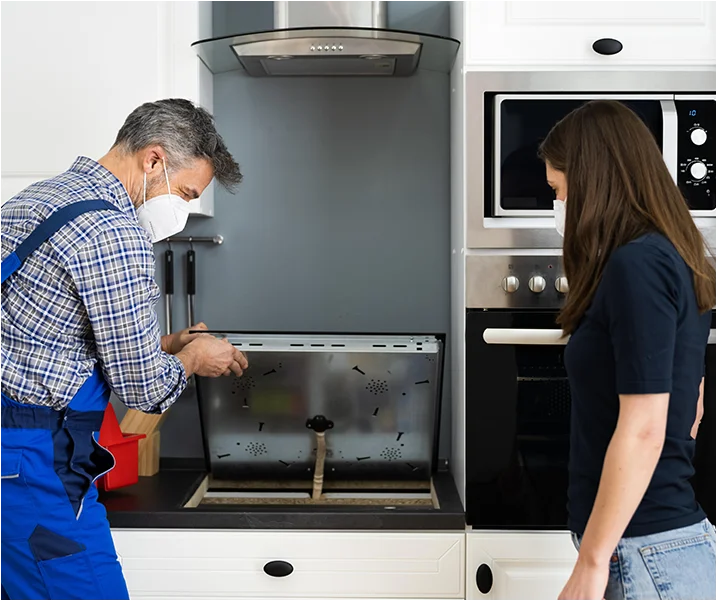 tech in  kitchen repairing oven