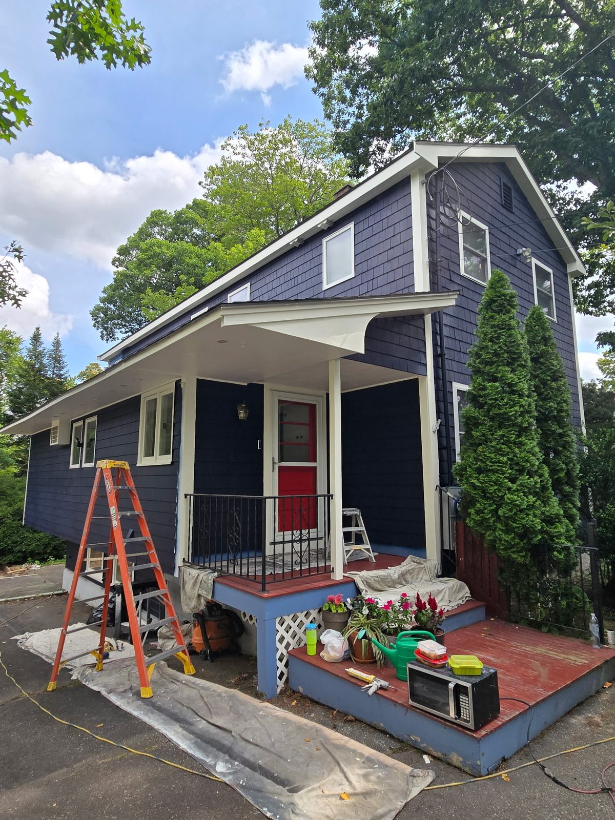The same house finished in deep navy with fresh white trim and a red front door.