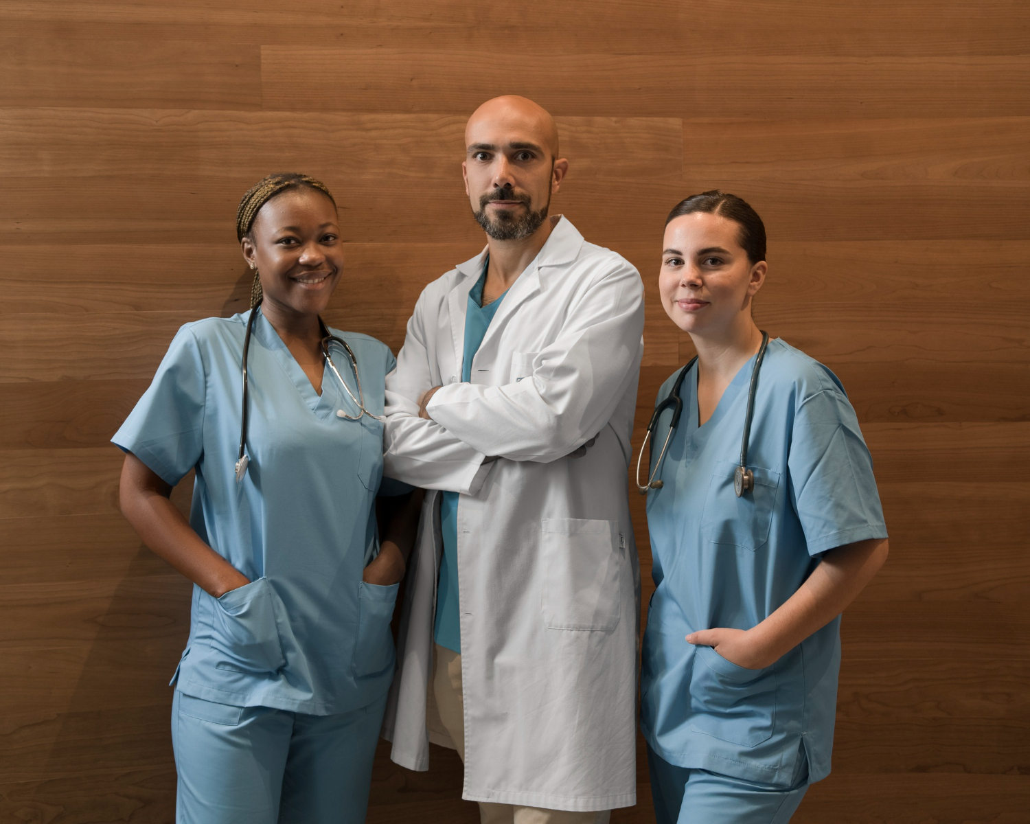 Portrait of two female nurses at the clinic with male doctor