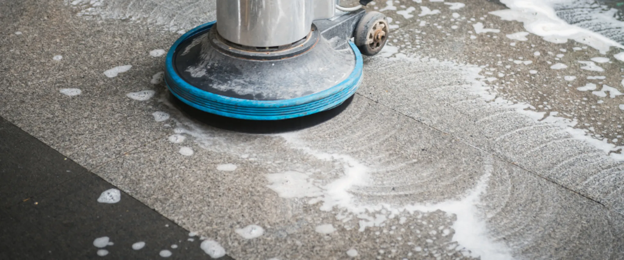 Floor scrubber machine cleaning stone surface with foam