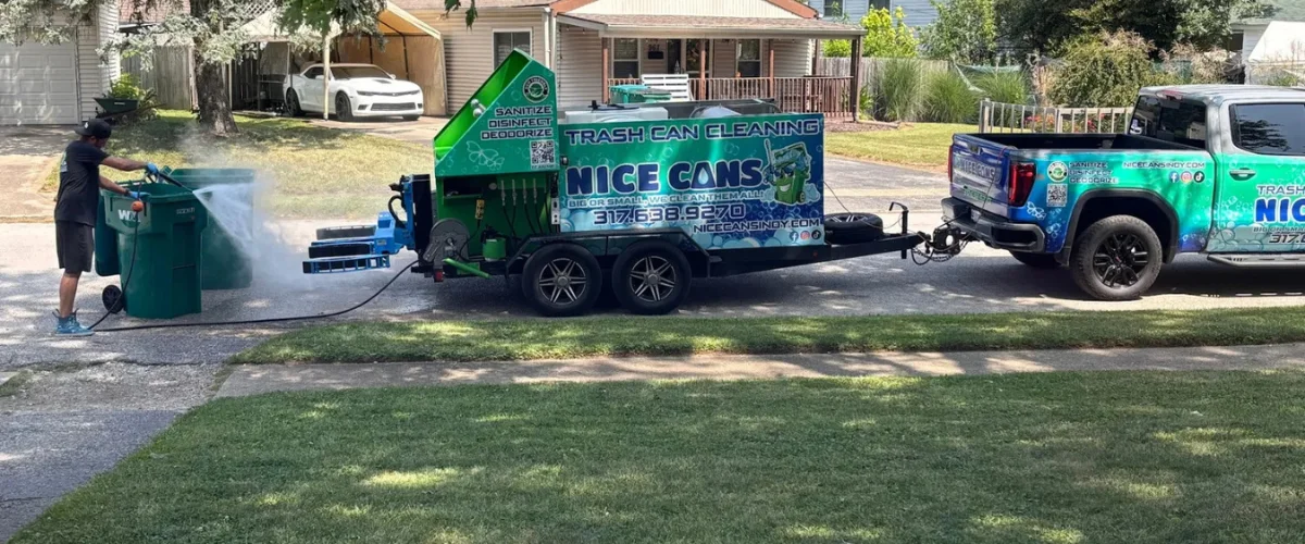 A man pressure washing a green trash can next to a 'Nice Cans' branded truck and cleaning trailer.