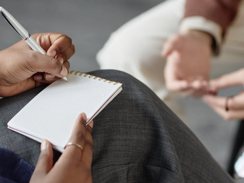 A counsellor taking notes in session