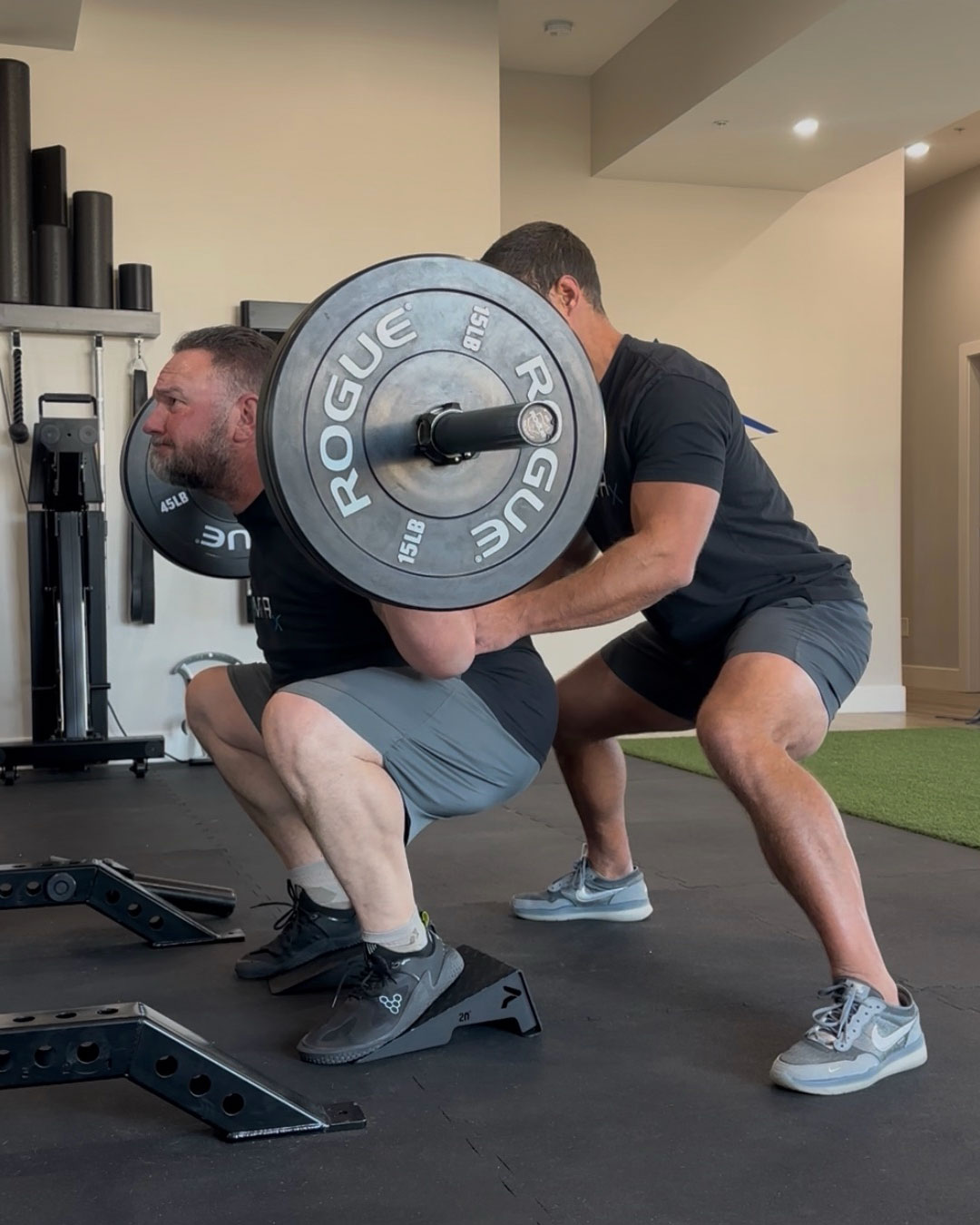 Dr. Kyle spotting a patient through a loaded exercise for knee osteoarthritis rehab at MVMT Rx Sports Care and Chiropractic in Sparks NV