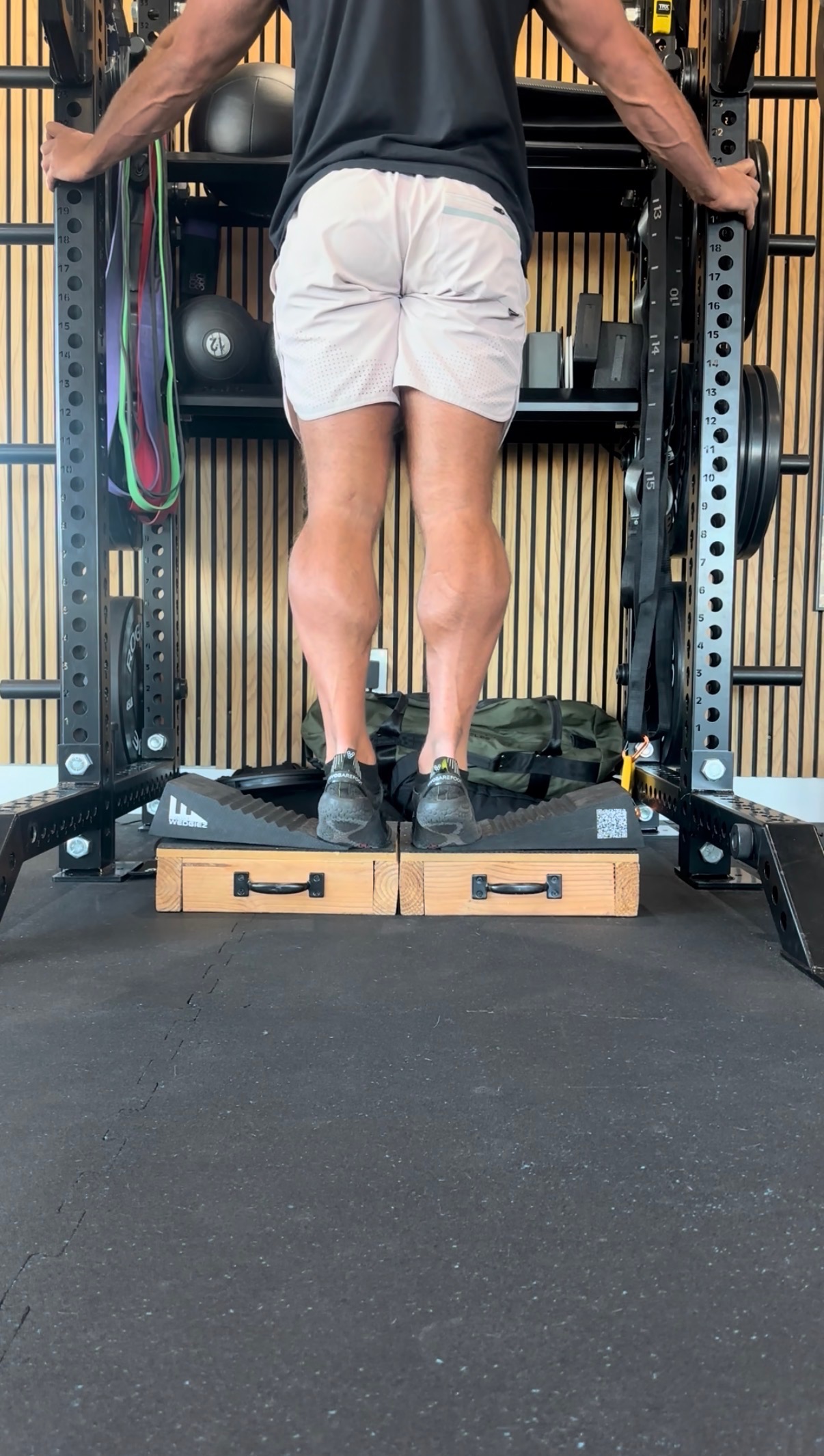 Dr. Kyle Hemsley performing loaded calf raises on wedges for progressive Achilles tendon loading at MVMT Rx in Sparks NV