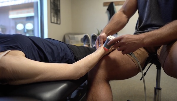 Class IV laser therapy being applied to a patient's knee at MVMT Rx in Reno, NV