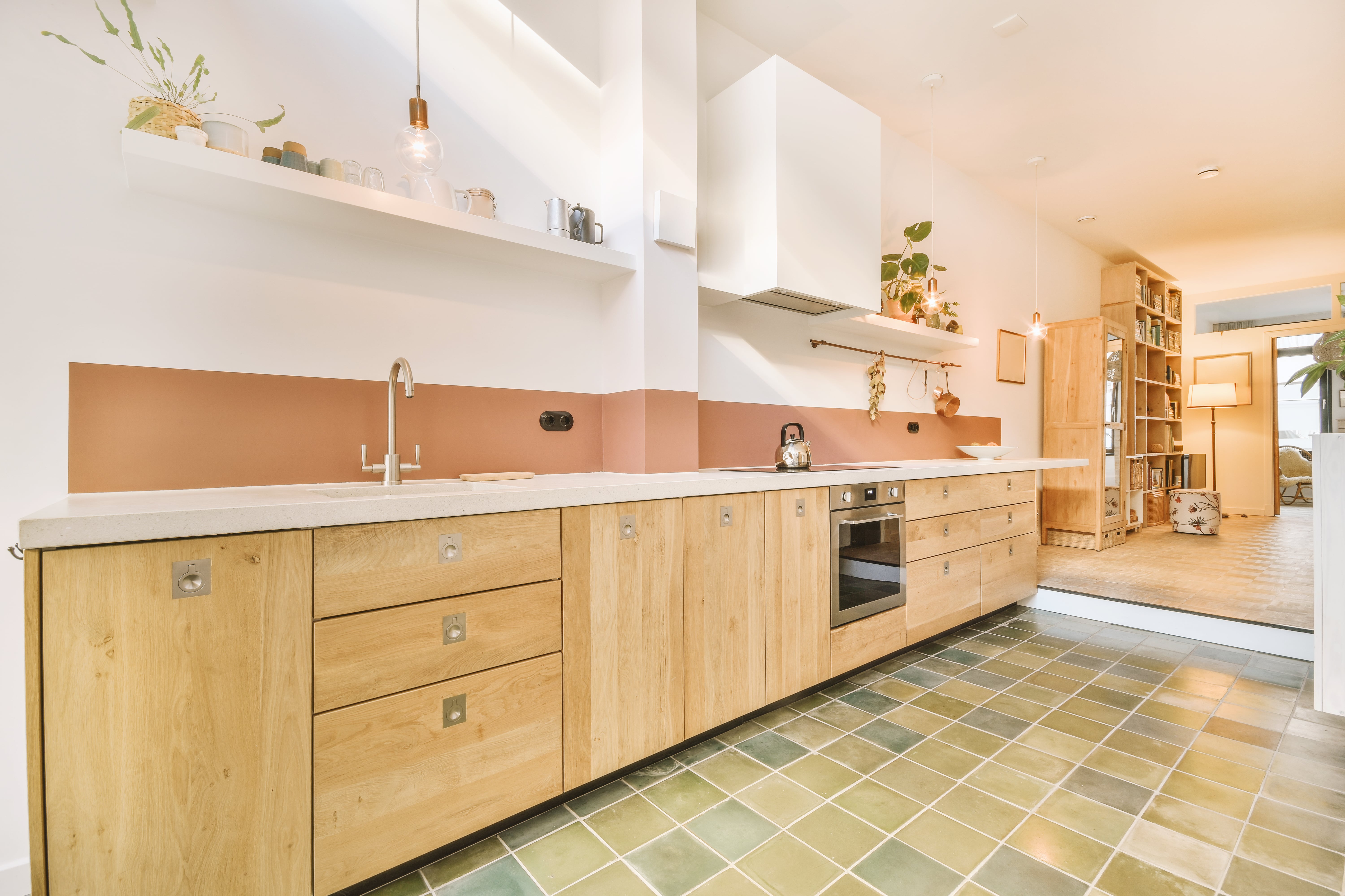 a kitchen with wood cabinets and green tile floor