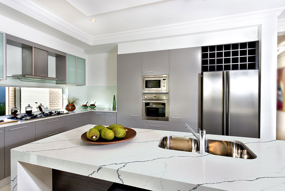 a kitchen with a bowl of fruit on a marble countertop